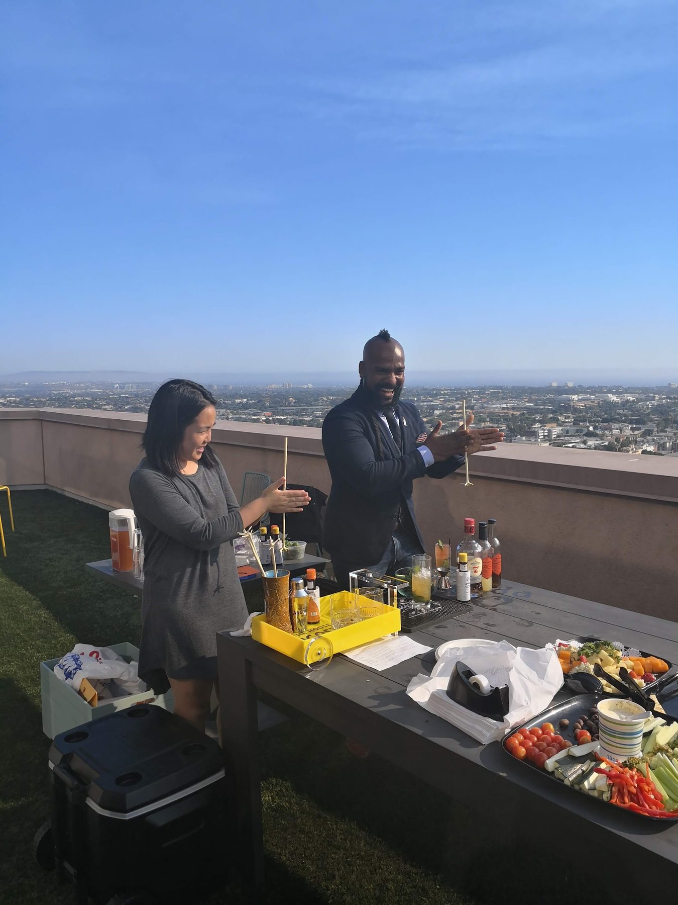 A rooftop bar setup with the Los Angeles skyline behind it