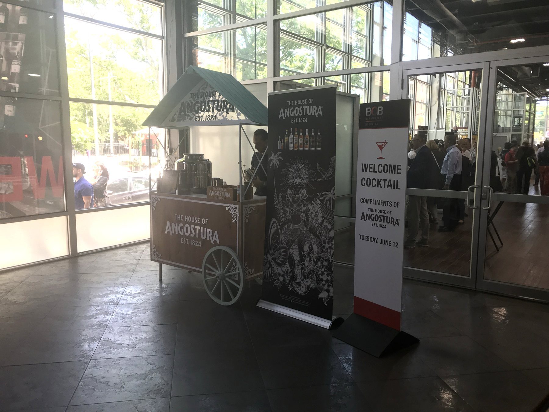 A branded House of Angostura cocktail cart beside a 'Welcome Cocktail, compliments of the House of Angostura' sign at Bar Convent Brooklyn