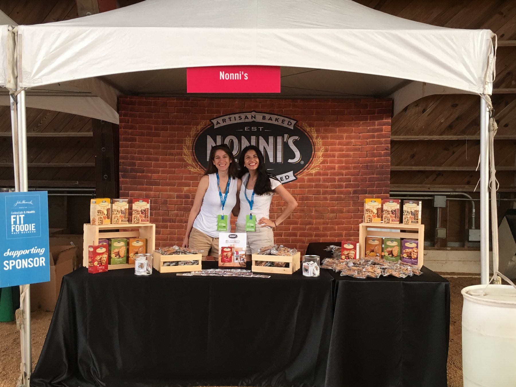 Nonni's booth with a brick backdrop, product displays and a 'Supporting Sponsor' sign