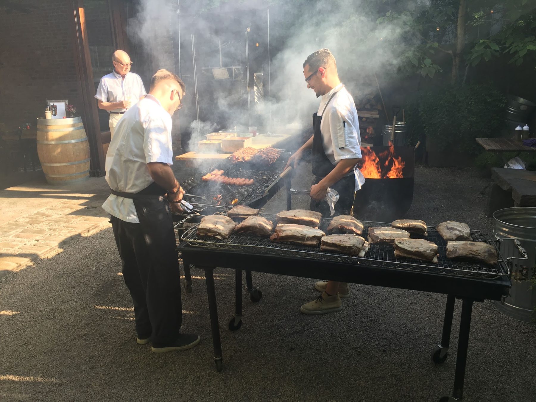 Chefs grilling meat over an open fire