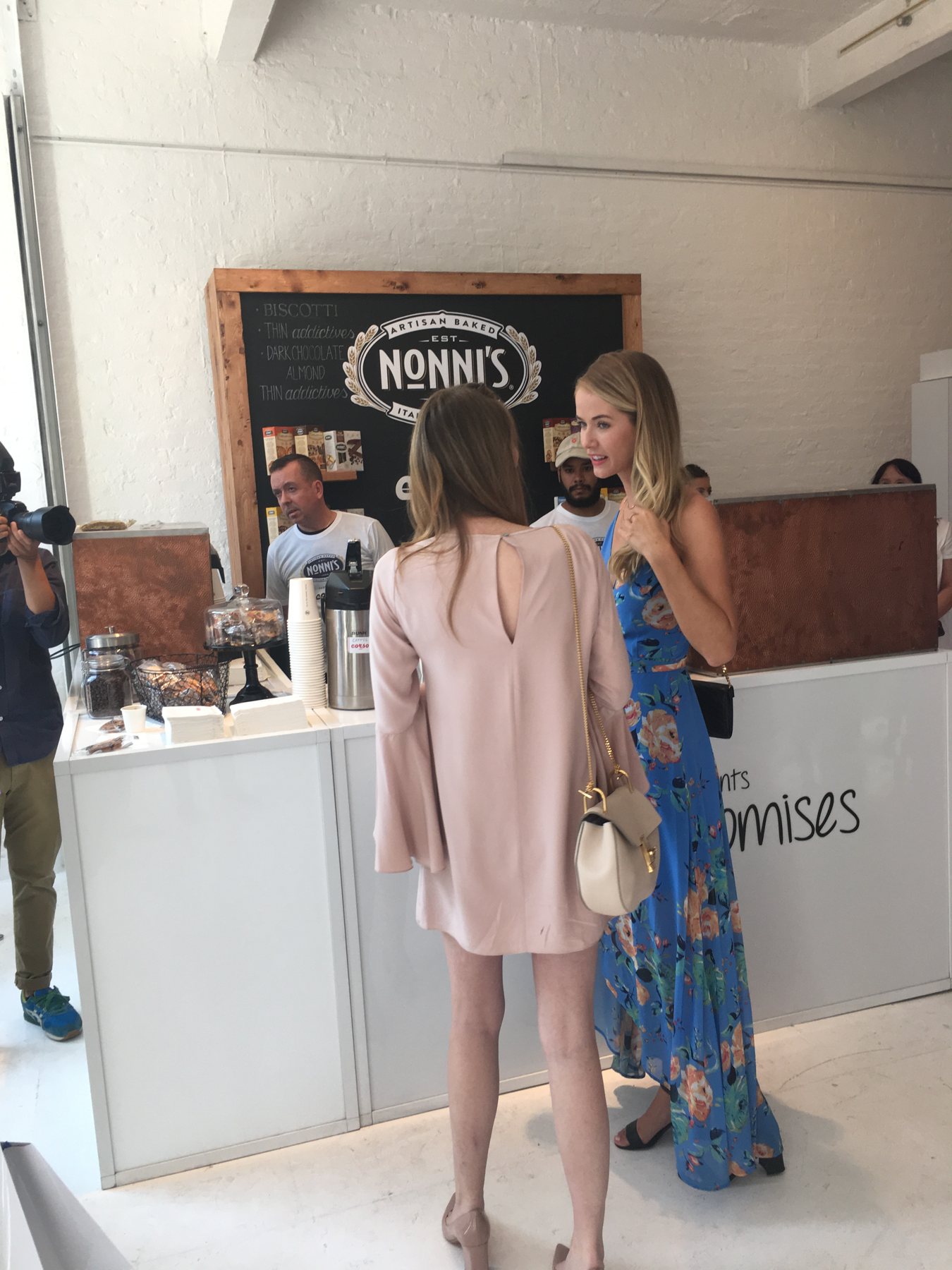 Guests at the Nonni's café counter while a photographer shoots